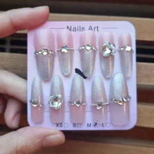 Handmade Lösningar Strl M - 10st  långa lösnaglar i storlek M. Naglarna är ljusrosa med silvrig glittereffekt som glittrar fint i ljuset. Tillverkad av matt akryl av hög kvalitet, som är stark och hållbar.              Mått ( båda vänster och höger är samma). Tumme        1,7 cm bredd längd 3 cm Pekfinger    1,5 cm bredd längd 2,7 cm Långfinger  1,5 cm bredd längd 2,7 cm Ringfinger   1,5 cm bredd längd 2,7 cm Lillfinger      1,3cm  bredd längd 2,7 cm  OBS! Storleken är baserad på manuell mätning och kan variera med 1–2 cm.