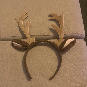 Renhorn diadem Halloween  - Roligt diadem i mjuk plysch med bruna renhorn och små öron. Perfekt accessoar för jul eller maskerad. Diademet är täckt i brunt tyg och har detaljer i beige och vitt på öronen.