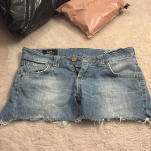 Ljusblå jeansshorts från Lee - Säljer ett par ljusblå jeansshorts från Lee med råa, fransiga kanter . Shortsen har gylf med dragkedja och knapp med Lee-logga. Köpta på second hand för länge sen, står ingen storlek men skulle säga xs. de är låga i midjan. Skriv om ni har frågor💕