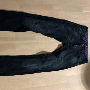 Svarta G-Star RAW Powell jeans W32 L34 - Säljer ett par svarta G-Star RAW Powell jeans med snygg tvätt och raka ben. Jeansen har klassiska fem fickor, bälteshällor och lila innerfoder i midjan. Tillverkade i bomull med en skön passform som funkar till många stilar.