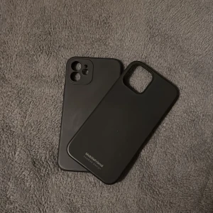 Två svarta iPhone 12 Skal - Båda anpassade för iPhone 12. Skalen är i fint skick utan synliga repor eller skador. Perfekt för att skydda din iPhone mot vardagsslitage.