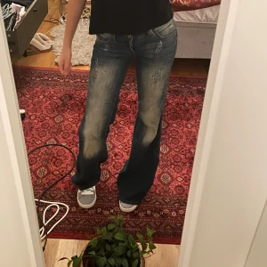Blå bootcut jeans från cheap monday - Säljer ett par blå/beiga bootcut jeans från cheap monday med slitna detaljer och ljusare partier framtill. Jeansen har låg midja. Använda max 3 gånger, W26 L32. Pris går diskuteras!