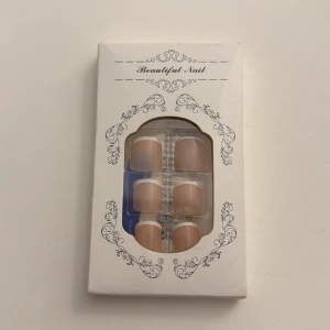 Beige lösnaglar i ask - Snygga lösnaglar i en naturlig beige nyans, levereras i en elegant vit ask med dekorativa detaljer. Naglarna har en klassisk, lätt rundad form och passar perfekt för en stilren look. Materialet är plast och förpackningen innehåller flera naglar i olika storlekar. För tå naglarna om du ej orkar gå och göra en pedikyr men vill ha klackar Elr bara känna sig fin, helt nya ej öppnad.