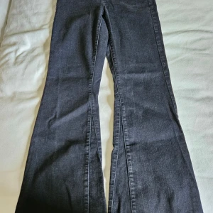 Svarta bootcut jeans från Pimkie - Snygga svarta jeans från Pimkie med bootcut passform. Jeansen har klassisk femficksdesign och är tillverkade i mjukt denim-material som sitter skönt. Perfekt för dig som gillar en lite vidare siluett nertill och vill ha en cool look.