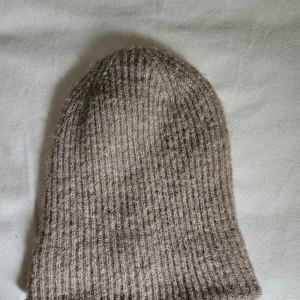 Beige ribbstickad mössa Even&Odd - Ribbstickad beige mössa från Even&Odd i mjukt och varmt material. Klassisk form med enkel design som passar perfekt till kyliga dagar. Snygg neutral färg som är lätt att matcha med olika outfits.