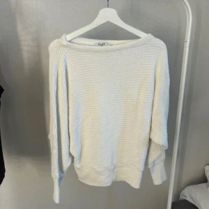 Vit stickad tröja från NA-KD XS - Supermysig vit stickad tröja från NA-KD i storlek XS. Tröjan har en avslappnad passform med bred halsringning och långa ärmar. Perfekt att slänga på sig när det är kyligt ute. Ribbstickade muddar vid ärmslut och nederkant ger en snygg touch.