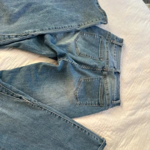 Ljusblå jeans från Folkyrose - Säljer ett par ljusblå jeans från Folkyrose med rå kant upptill i midjan och klassisk femficksdesign. Jeansen har raka ben och är tillverkade i denim med snygg tvättad look. Perfekta för dig som gillar en avslappnad stil.ord pis något med 700kr säljer 399