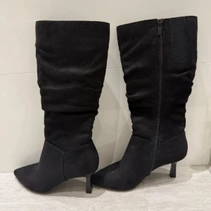 Svarta mocka stövlar med klack  - Eleganta svarta stövlar i mocka med spetsig tå och smal klack. De har en praktisk dragkedja på sidan för enkel på- och avtagning. pris kan diskuteras💞💞