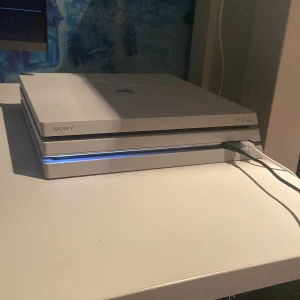 PlayStation 4 Pro Glacier White - Snygg PlayStation 4 Pro i Glacier White. Pset låter som ett flygplan men allt funkar bra på den. En kontroll ingår