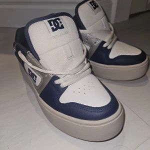 DC Shoes sneakers i blått och vitt - Snygga sneakers från DC Shoes i blått och vitt med tjock, beige sula. Skorna har klassisk DC-logga på sidan och plösen, snörning och ventilerande meshdetaljer. Perfekta för dig som gillar streetstyle och skate-inspirerad look.                   ❗️orginalpris 1200kr❗️