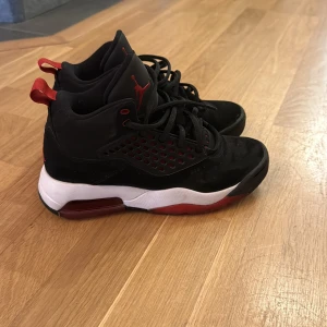 Nike Jordan sneakers svart/röd 36.5 - Grymma Nike Jordan sneakers i svart och rött med vit mellansula och synlig Air-enhet. Skorna har snörning, perforerade paneler och Jumpman-logga på plösen. Snygg design med högt skaft och platt sula, perfekt för dig som gillar streetstyle och basketvibe.