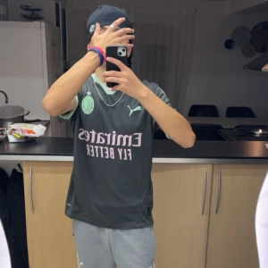 AC Milan tredje tröja Puma M kostar 1150kr - AC Milan tredje fotbollströja från Puma i mörkgrått med mintgröna detaljer på krage och ärmslut. Tryck i ljusrosa med Emirates Fly Better och MSC på ärmen. Materialet är lätt polyester med DryCell-teknologi för fukttransport. Snyggt broderat klubbmärke på bröstet.