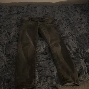 Slim fit jeans från Jack & Jones - Slim fit jeans från Jack & Jones i mörkgrå färg. Klassisk femficksmodell med dragkedjegylf och bälteshällor. Snygg, smal passform som sitter tajt över benen. Perfekta för dig som gillar en modern och stilren look. Dom är andvända två gånger 