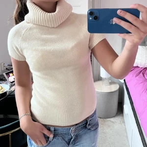 Beige stickad polotopp - Säljer en beige stickad polotopp med korta ärmar och bred ribbad polokrage. Perfekt för lager-på-lager och passar till många olika stilar. Enkel och stilren design. Perfekt till vår, höst , sommar och vinter!Perfekt till vår, höst , sommar och vinter! Vet ej vad märket är eller storlek men passar mig som bär storlek S och Xs men även M 