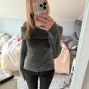 Mörkgrå offshoulder stickad tröja H&M - Supermysig mörkgrå stickad tröja från H&M med offshoulder-krage. Tröjan har ribbad struktur och långa ärmar, perfekt för dig som gillar en chill men ändå snygg look. Passar dig som vill ha något lite extra till hösten och vintern. Använd endast någon fåtal gång så den är nästan oanvänd. Nypris 299kr