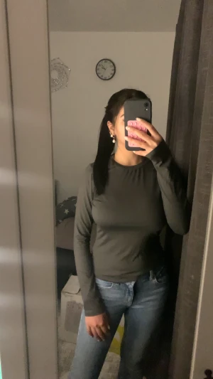 Mörkgrå långärmad basic tröja - En stilren mörkgrå långärmad tröja i enkel och klassisk modell. Tröjan har rund halsringning och är tillverkad i mjukt bomullsmaterial. Perfekt att matcha med jeans eller kjol för en clean look.