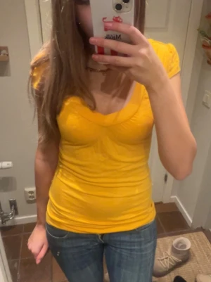 Vintage gul topp  - Säljer en gul topp från Ann Christine i storlek S. Modellen är v-ringad med korta ärmar och figurnära passform. Tunn och mjuk bomullskvalitet som känns skön mot huden. Perfekt att styla med jeans eller kjol för en färgglad look. Säljer liknande snygga plagg i min profil! 🩷