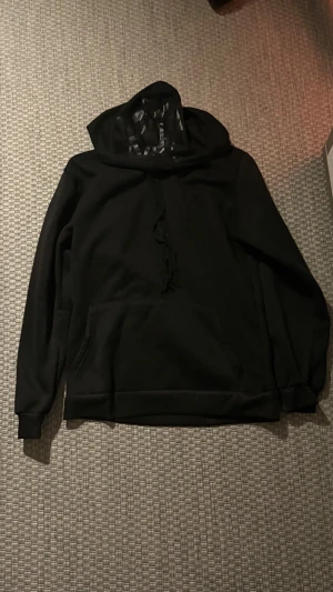 Svart Syna World hoodie - Skön svart hoodie från Syna World👌🏽Passar riktigt skönt, perfekt för chill eller träning🏋️ Bra skick knappast använd. Hör gärna av för frågor eller snabba affärer🤝