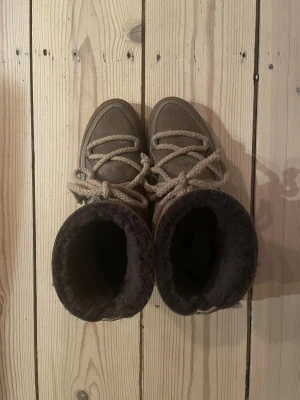 Inuikii vinterskor storlek 39 - Inuikii vinterskor i brun/beige färg, storlek 39. Original pris 3000kr. En skrapa på ena skon, syns på bilden, men annars i mycket bra skick. Kan diskutera om priset!