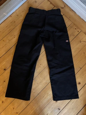 Svarta Dickies loose fit byxor W28/L30 - Svarta Dickies byxor med loose fit och raka ben. Flera fickor och robust dragkedja. Tillverkade i slitstark bomull. Säljer pga att jag inte kommit till användning av dem💕