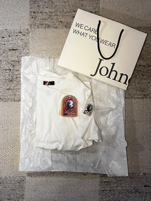 Parajumpers (SHISPARE) - Vit Parajumpers T-shirt änvänd sparsamt fåtal gånger, köpt på Johnells i (april 2024).                                -Nypris ≈ 850kr                                                        -Skick: 9.5/10                                                                         Hör av dig vid frågor och funderingar!