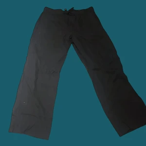 Svarta linnebyxor från H&M relaxed fit - Svarta linnebyxor från H&M med relaxed fit och snörning i midjan. Byxorna har en rak och loose passform, perfekt för chill dagar. Materialet är linne som ger en skön och luftig känsla. Enkel design utan mönster eller extra detaljer.