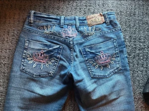 Miss O&Y jeans - Snygga blå jeans från miss O&Y jeans med bootcut passform och låg midja. Baktill finns broderade rosa kronor och blad på fickorna samt fina små stenar. I nytt skick och knappt använda. Säljer på grund av att dem är för små för mig. Det står storlek 36 alltså S men jag tycker dem är mer XS💗