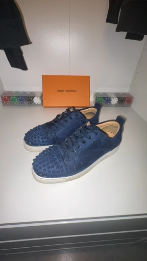 Louboutins mörk blå  - Louboutins vit och mörk blått, 2 nitar saknas, låda med annat tillbehör OBS! inga extra nitar