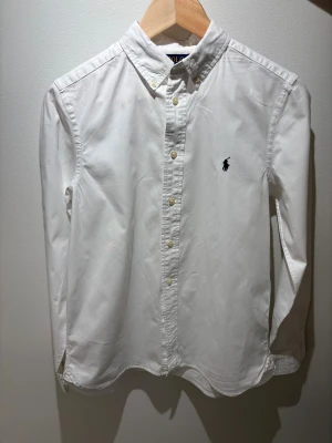 Ralph lauren skjorta S - Tja, jag säljer nu min Polo Ralph Lauren skjorta i slim fit-modell. Skjortan har lång ärm, knappar framtill och ikonisk broderad logga på bröstet. Tillverkad i bomull och har en stilren, tidlös look med button down-krage. Skjortan passar perfekt till dig som är ungefär mellan 160-170 cm