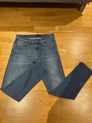 Tiger of Sweden jeans - Säljer ett par klassiska blå jeans  Jeansen har fem fickor, normal midja och en snygg tvätt med lätt slitning. Materialet är mjukt och stretchigt jeans-tyg som sitter tajt längs benen. Perfekta till sneakers eller boots.