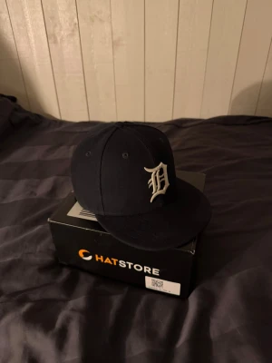 Mörkblå New era keps - Säljer en mörkblå New Era 59FIFTY keps med broderad MLB-logga framtill och officiella märken på sidan och bak. Klassisk rak skärm och snygg passform. Perfekt för dig som gillar streetwear och sportig stil. Endast lite smuts på märket bak men borta med en tvätt.