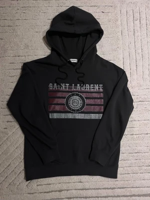 Saint Laurent  - En tvär fet YVES Saint Laurent hoodie i riktigt fint skick! Tröjan är som ny har änvänt väldigt få gånger och tvättat tröjan en gång! Skicket är väldigt bra. Priset går att diskutera men kom inte med några skammbud eller något sånt! Storlek M men passar storlek S också. Skriv för mer information. Först till kvarn!😌