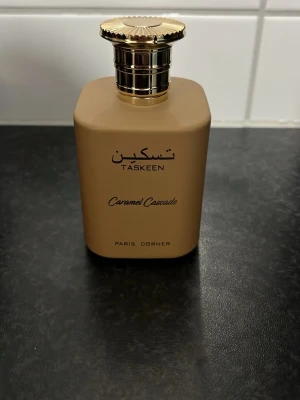 Taskeen Caramel Cascade parfym - Upptäck Taskeen Caramel Cascade från Paris Corner – en stilren parfym med modern design. Perfekt för dig som vill sticka ut och addera en lyxig touch till din doftsamling.