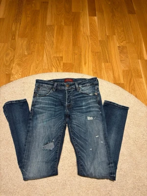 Mörkblåa Jack & Jones jeans med slitningar - Säljer ett par Slim Glenn jeans från Jack & Jones i mörkblå färg. Dom sitter bra och kostade 750. 