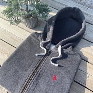 Grå zip hoodie från Ralph Lauren - Tjena! Säljer en mörkgrå zip hoodie från Polo Ralph Lauren i storlek XS. Det är riktigt bra skick och passar dig som är runt 170 till 175 cm. Vid frågor är det bara att skriva!🥂 priset inte hugget i sten
