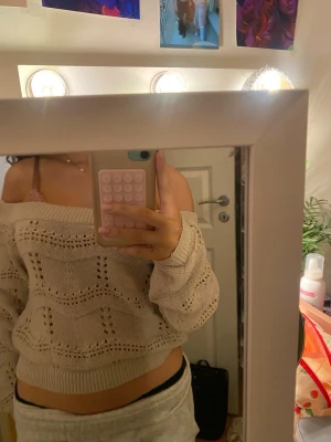 ONLY tröja  - Säljer en beige stickad tröja med offshoulder-design och snyggt hålmönster. Tröjan är croppad och har långa ärmar med bred mudd. Perfekt för dig som vill ha en chill men ändå söt look.