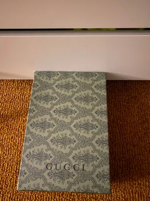 Gucci Ace sneakers med orm brodyr - Gucci Ace sneakers i vitt skinn med klassiska gröna och röda ränder på sidorna. Ena sidan har en broderad orm i rött, svart och vitt. Baksidan har metallicröd och metallicgrön detalj med Gucci-logga. Snygga och ikoniska sneakers med snörning och platt sula. Storlek 44! 
