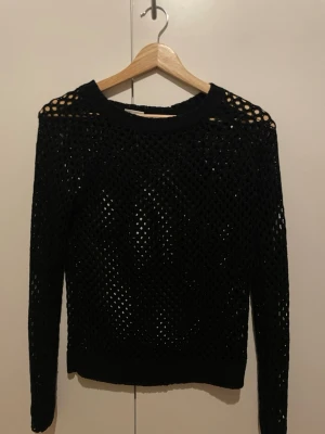 Svart stickad tröja från Cubus XS - Svart stickad tröja från Cubus i storlek XS. Tröjan har ett coolt hålmönster över hela och rund hals. Långärmad och perfekt för lager-på-lager. Passar dig som gillar en lite edgy och unik stil.
