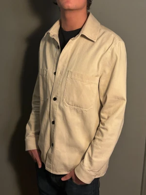 Arket overshirt - Säljer en beige overshirt från Arket i storlek EU 50. Skicket ligger på 8/10 då den är använd ett fåtal gånger.