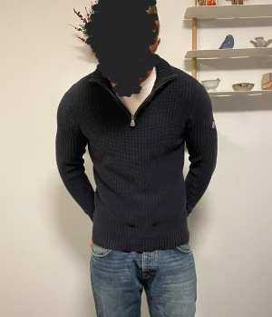 Stickad Henry Lloyd tröja - En stickad Henry Lloyd quarter zip i storlek S som passar flera, första modellen är 183cm lång och andra modellen är 173cm lång, båda har tröjan i storlek S. Riktigt snygg oavsett build.