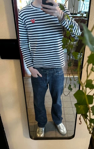 Raw selvedge mörkblå Stone Island jeans - Säljer ett par mörkblå jeans från Stone Island med raka ben och klassisk femficksdesign. Jeansen har snygga kontrastsömmar och en diskret logga vid hällan. Tillverkade i robust denim som ger en clean och tidlös look. Jeansen är även Raw selvedge (alltså gjorda på ett specifikt sätt— ofta kopplat med högre kavlité).  Jeansen säger W33 men passar mer som W30/L30.