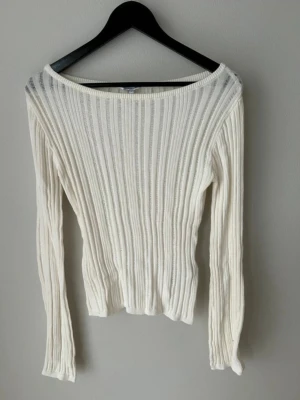 Vit ribbad stickad tröja Bubbleroom - Snygg vit stickad tröja från Bubbleroom i storlek S. Tröjan har ett ribbat mönster, lång ärm och en bred, något båtringad hals. Perfekt för dig som gillar en clean och fräsch look med lite struktur. Passar dig som vill ha en smickrande och enkel stil.