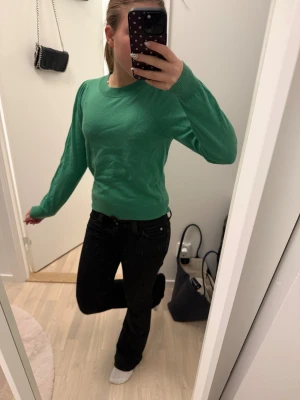 Grön stickad tröja Part Two XS - Snygg grön stickad tröja från Part Two i storlek XS. Tröjan har rund hals, puffade axlar och långa ärmar med ribbade muddar. Perfekt för dig som gillar enkel stil med en färgklick. Supermjuk och skön att ha på sig.