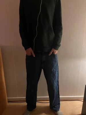 Blåa jeans från Sweet Skateboarding - Säljer ett par blåa jeans från Sweet Skateboarding Company. De har en loose passform med raka ben och klassisk femficksdesign. Jeansen har en mörkblå tvätt. Perfekta för en avslappnad och skön stil.