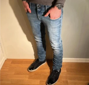 Replay anbass jeans  - Säljer ett par ljusblå skinny jeans med klassisk femficksdesign och snygga slitningar. Jeansen har normal midja och är tillverkade i stretchigt denim för en tight passform. Perfekta för dig som gillar en modern och smal siluett.