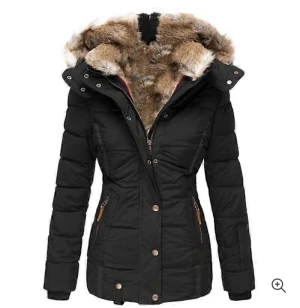 Svart pufferjacka med fuskpäls - Svart pufferjacka med mysig fuskpäls i huvan och snygga detaljer i brons. Jackan har dragkedja och knappar framtill, två fickor med dragkedja och figurnära passform. Perfekt för kalla dagar när du vill hålla stilen.Ståt storlek xl men liten i storlek som en M