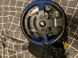 Thrustmaster T150 Racing Wheel - Thrustmaster T150 ratt och pedaler för PlayStation och PC. Fungerar med PS4 och PS3, har force feedback och realistiska pedaler. I gott skick, inga synliga skador eller större slitage. Perfekt för racing- och bilspel.