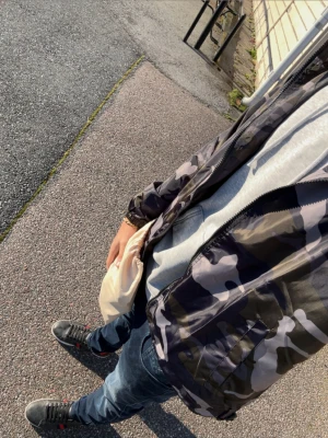 Camouflage vindjacka från Lindfors - Säljer en snygg vindjacka med camouflagemönster i svart, grått och grönt. Jackan har huva, dragkedja framtill och elastiska muddar vid ärmsluten. Perfekt för dig som vill ha en streetig look och gillar att sticka ut.