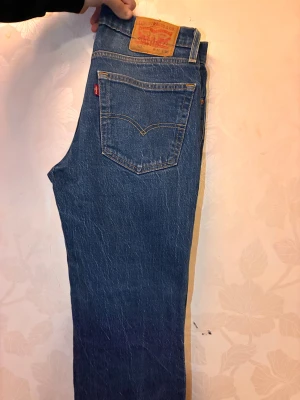 Levi's 516 blå jeans straight fit - Säljer ett par klassiska Levi's 516 jeans i blå denim med raka ben och normal passform. Jeansen har fem fickor, tydliga kontrastsömmar och den ikoniska läderpatchen bak i midjan. Perfekt för dig som gillar tidlös stil och schysst kvalitet.priset kan diskuteras naturligtvis!