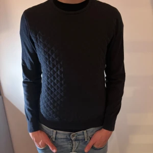 Mörkblå tröja Massimo Dutti - Snygg mörkblå tröja från Massimo Dutti i bomull. Tröjan har quiltat mönster framtill, rund halsringning och långa ärmar. Perfekt för dig som gillar stilrena och bekväma plagg.                         Liten i storleken!